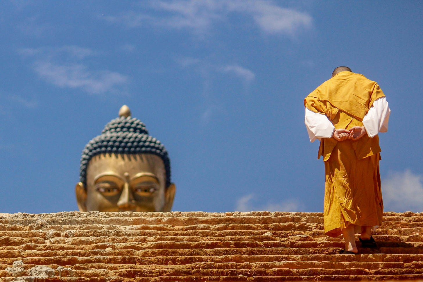 Monk walking up the stairs , buddha statue watching the monk. Anatta