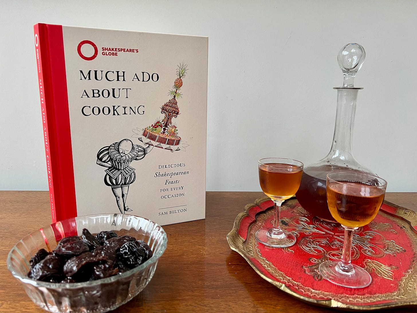 Dish of prunes, sherry decanter, 2 glasses sherry, Much Ado About Cooking recipe book