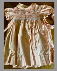 A pink dress on a table

Description automatically generated