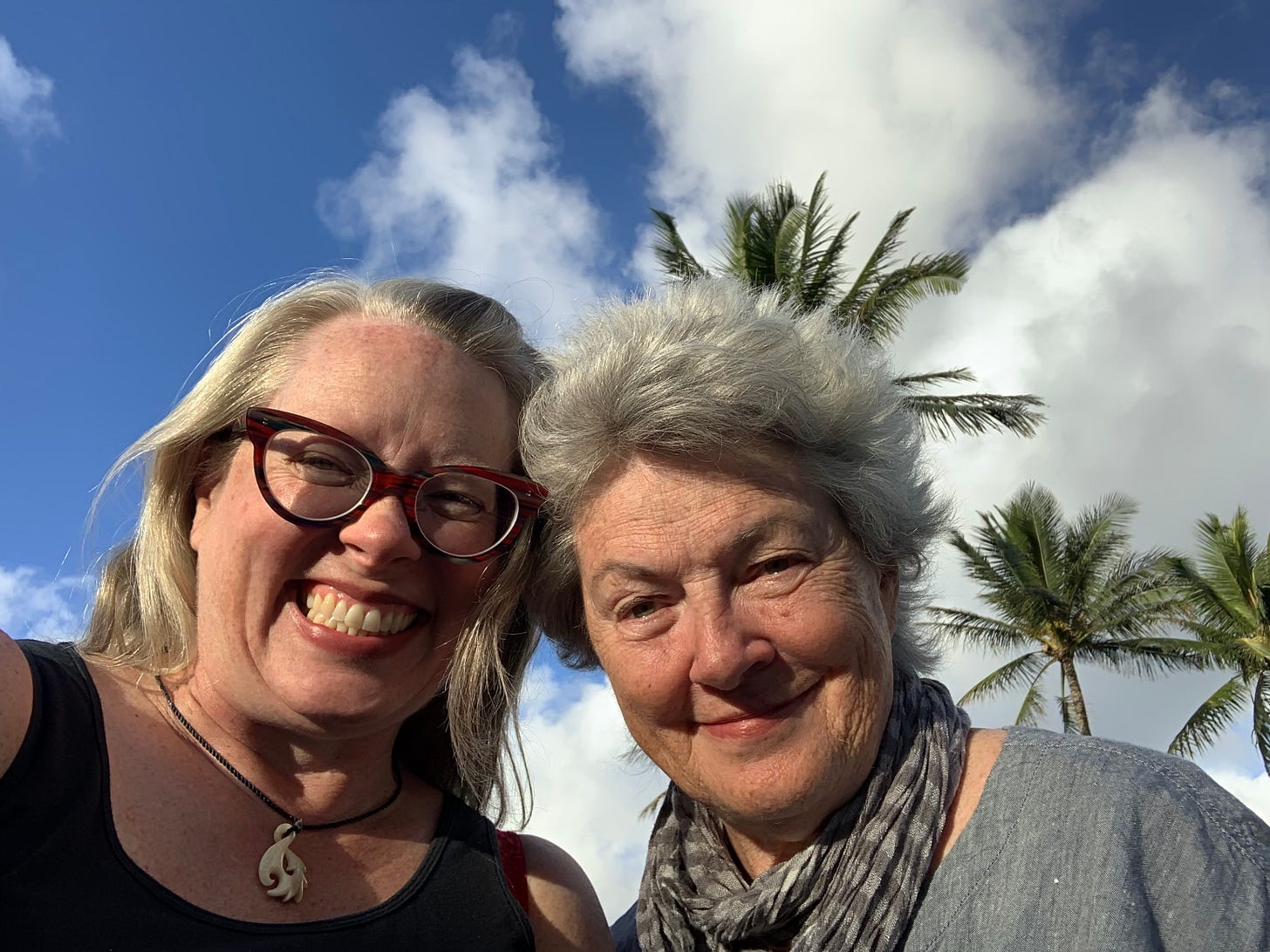 Selfie of two women with blue sky and palm trees in the background