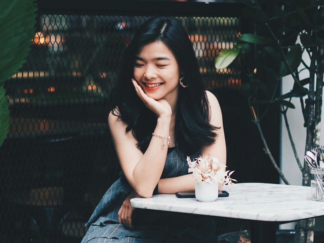 woman sitting and smiling beside table