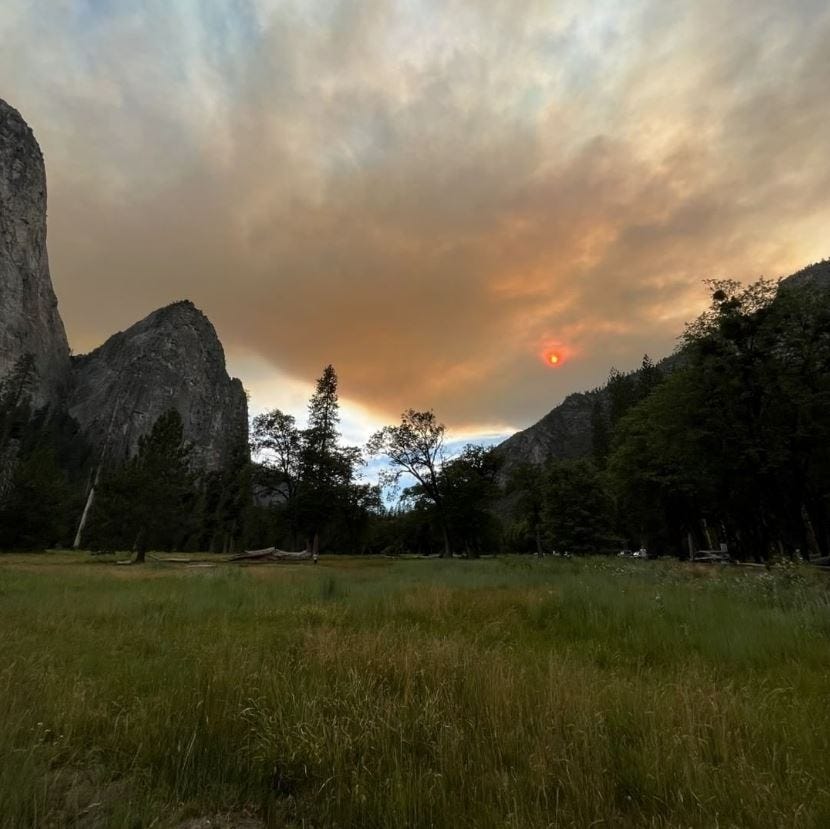 Prairie in the foreground, stone monoliths behind, and wildfire smoke covering the skies above. Prairie in the foreground, stone monoliths behind, and wildfire smoke covering the skies above.