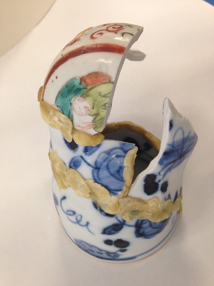 broken cups and plates are sorted and reassembled using wax, tape and fiber