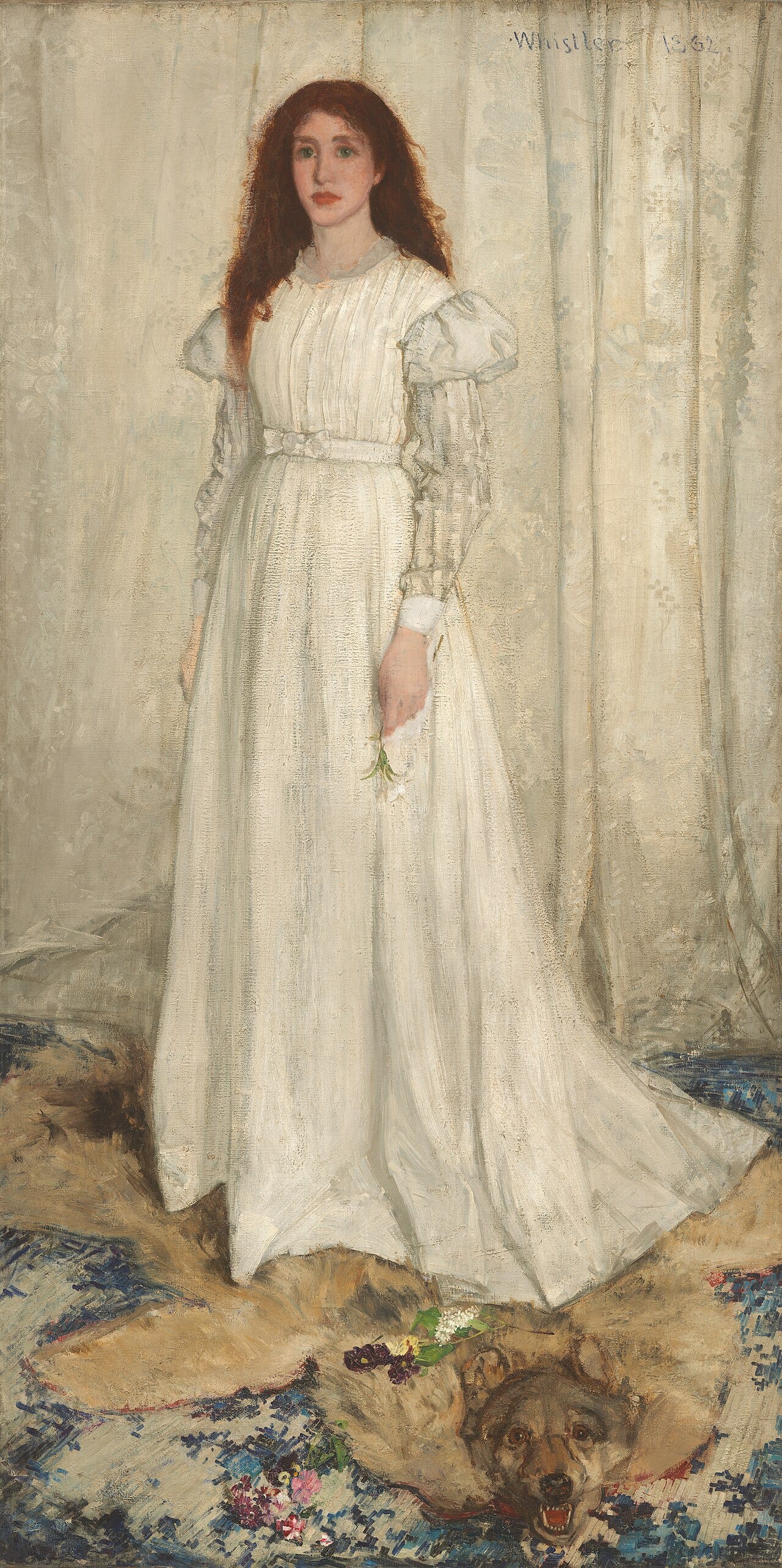 Woman in a white dress standing on a wolf skin rug in front of a white curtain Woman in a white dress standing on a wolf skin rug in front of a white curtain