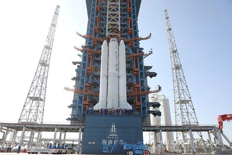 The Long March 8A's first and second stages being placed onto Commercial Launch Pad 1, while its fairing heads to the launch site.