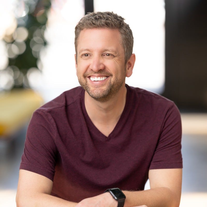 Chris smiling, arms folded casually in front of his torso