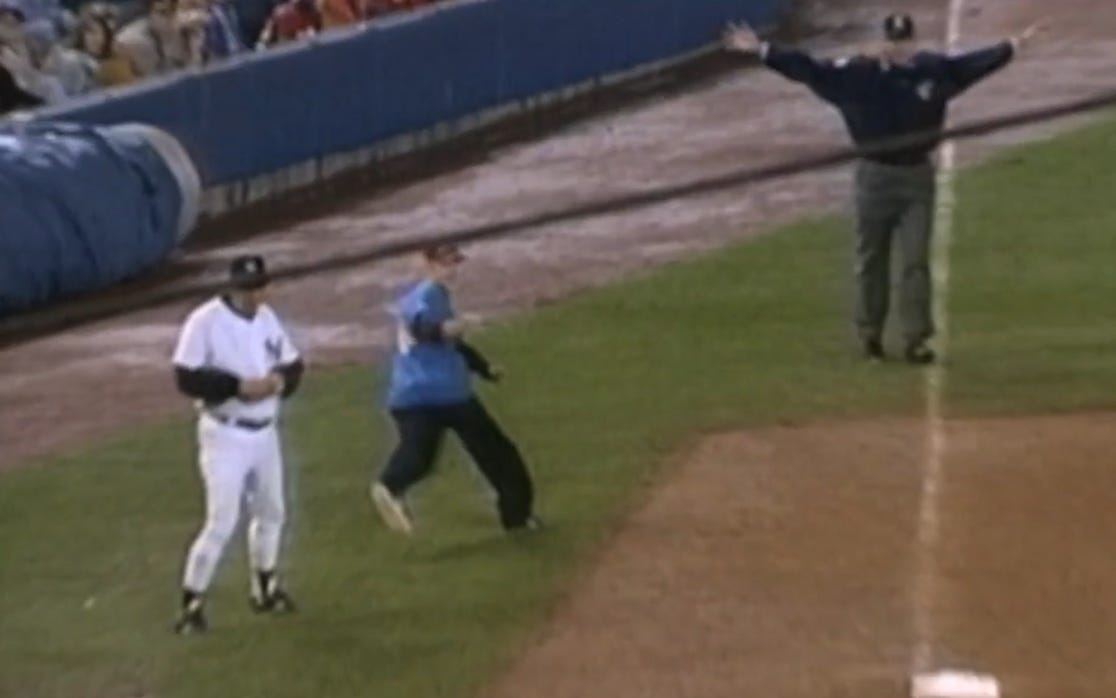A fan runs onto the field and into umpire Tim Welke's vision, prompting him to call timeout.