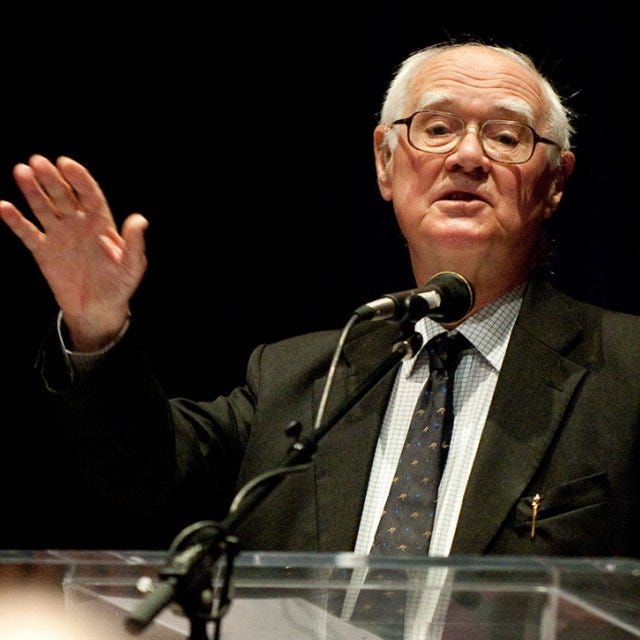 Polkinghorne, an older man, speaks from a podium to community in Crill Hall at PLNU Polkinghorne, an older man, speaks from a podium to community in Crill Hall at PLNU