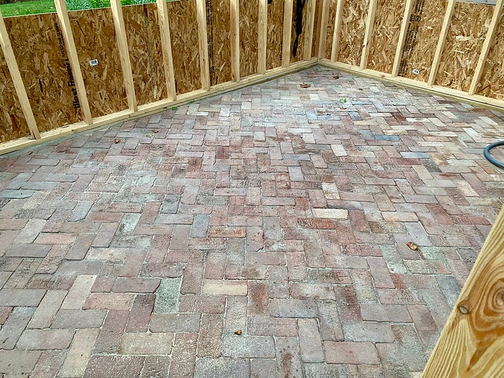 Mosaic of a brick paver floor being installed.