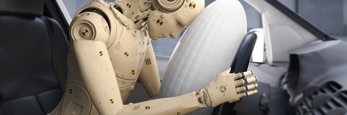 Photo of a car crash test dummy in a car where the air bag has been deployed