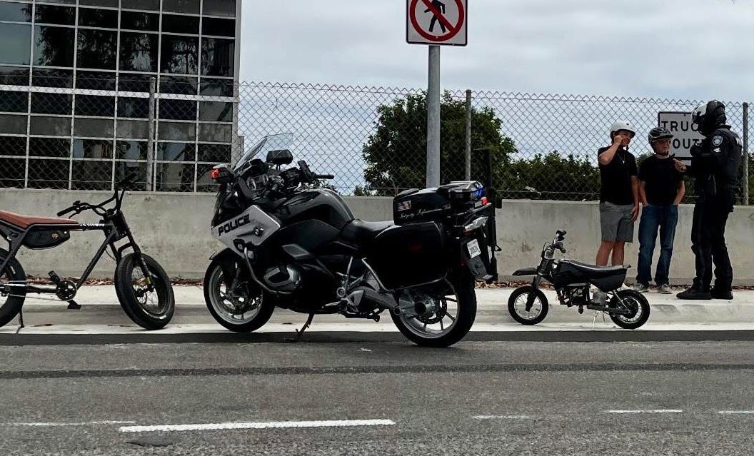 A Carlsbad police officer speaks with e-bike riders last year. The City Council approved a ban for e-bike riders under 12, plus several other new regulations. Courtesy photo