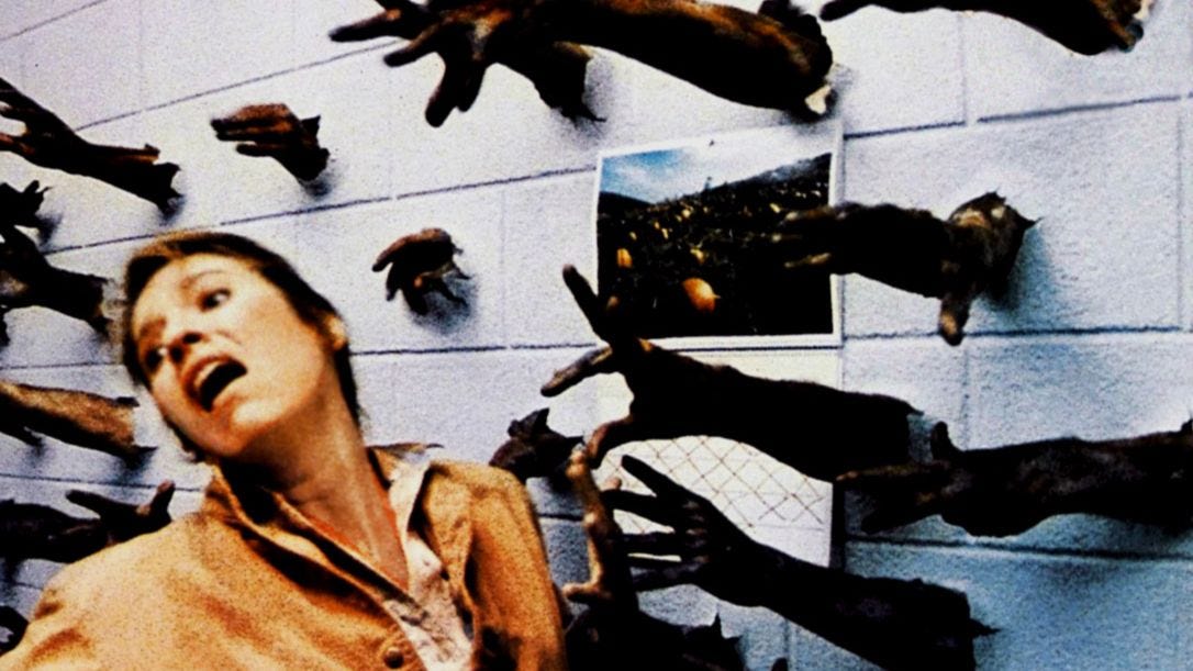 A woman turns away in horror from a wall of hands and arms reaching out to grab something.