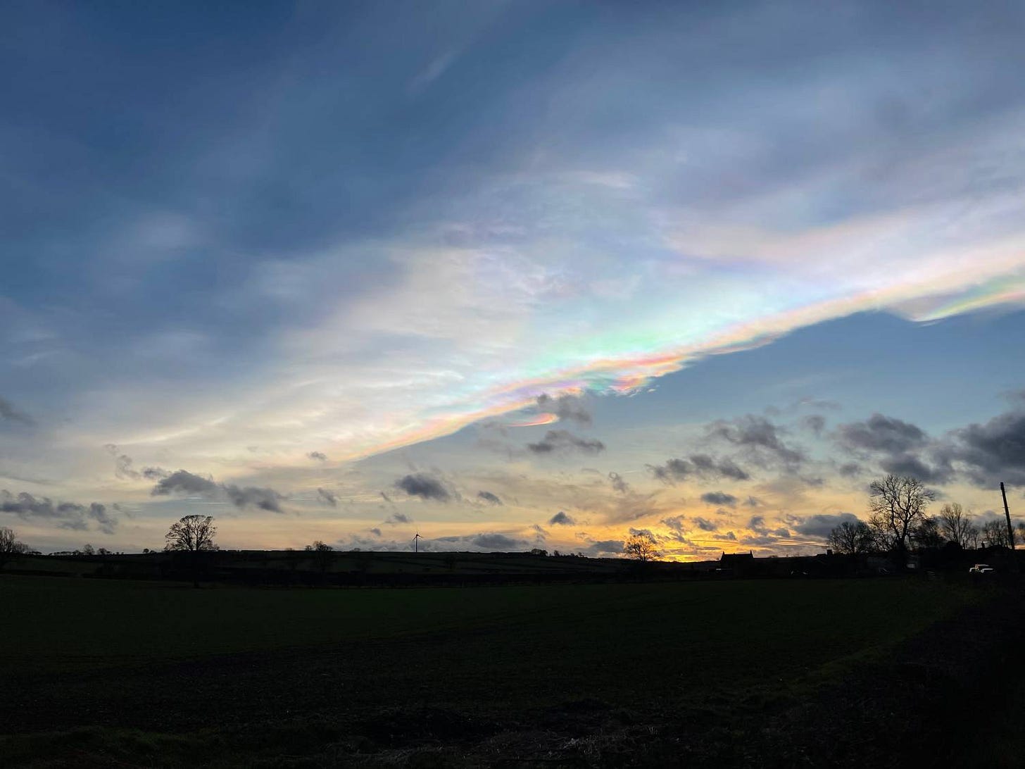 Rainbow-coloured nacreous clouds at sunset
