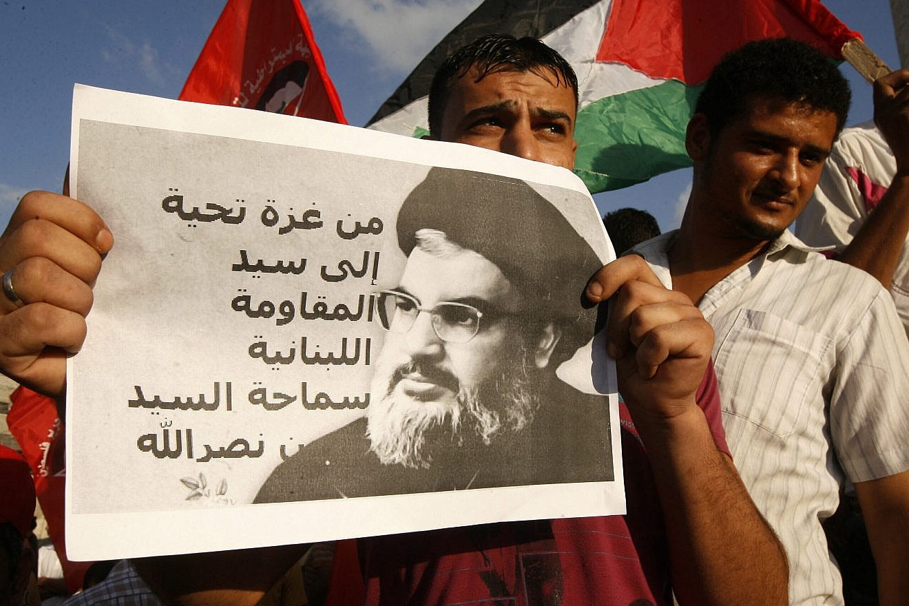 A Palestinian protester from the Popular Front for the Liberation of Palestine (PFLP) holds a picture of Hassan Nasrallah, the head of Lebanon’s militant Shi’ite Muslim movement Hezbollah, with a slogan that reads in Arabic “Regards from Gaza to the leader of Lebanese resistance” during a demonstration in Rafah, in the Southern Gaza Strip, on Sept. 3, 2014, against U.S. and French military intervention in Syria. Photo by Abed Rahim Khatib/Flash90. A Palestinian protester from the Popular Front for the Liberation of Palestine (PFLP) holds a picture of Hassan Nasrallah, the head of Lebanon’s militant Shi’ite Muslim movement Hezbollah, with a slogan that reads in Arabic “Regards from Gaza to the leader of Lebanese resistance” during a demonstration in Rafah, in the Southern Gaza Strip, on Sept. 3, 2014, against U.S. and French military intervention in Syria. Photo by Abed Rahim Khatib/Flash90.