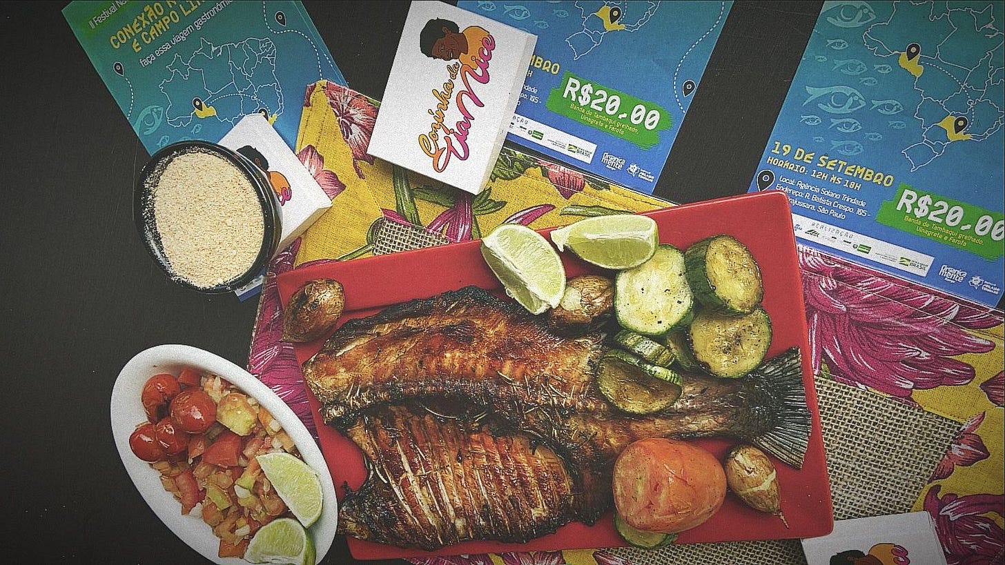 imagem mostra prato de peixe assado ao lado de travessa com farinha, acompanhado e fatias de limão