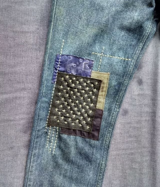 The knee of jeans with 4 overlapping patches The knee of jeans with 4 overlapping patches