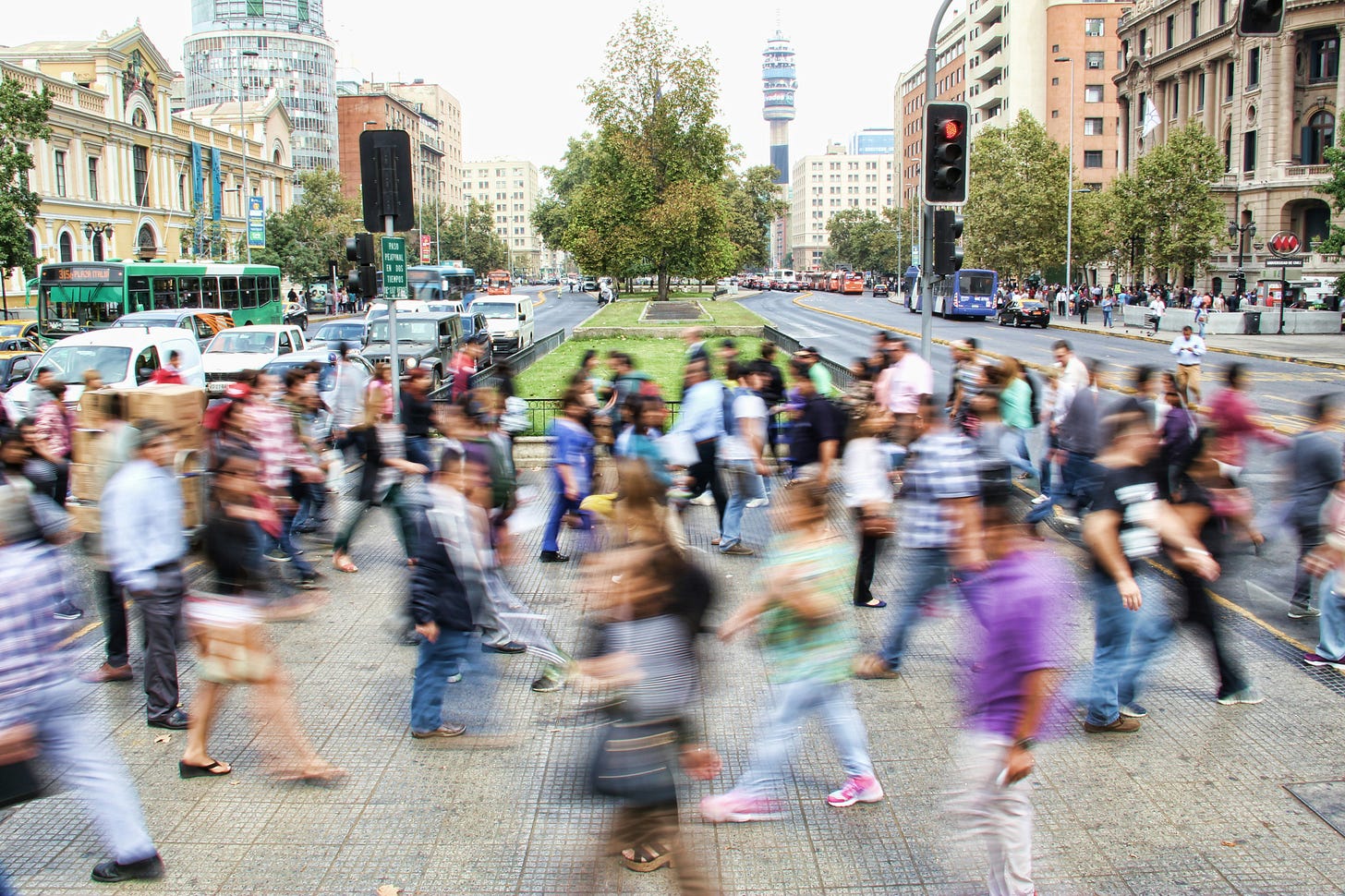 Blurry people in crowds rushing across a pedestrian crossing in an urban setting Blurry people in crowds rushing across a pedestrian crossing in an urban setting