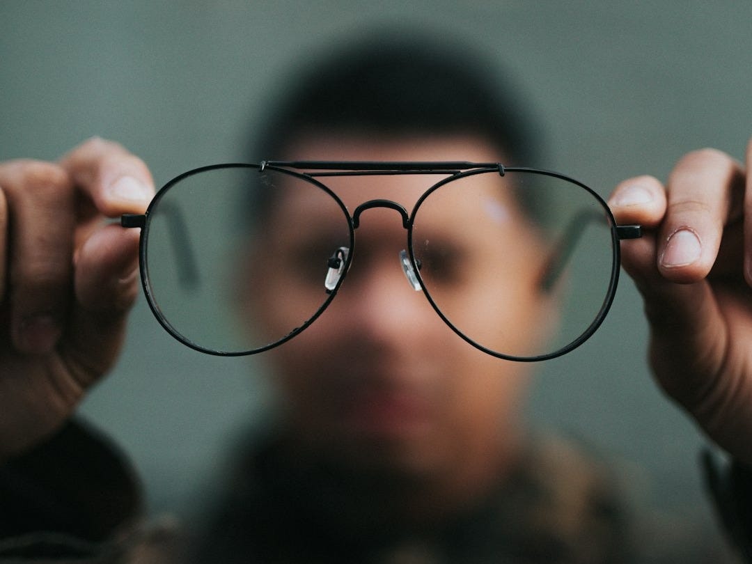 man holding eyeglasses