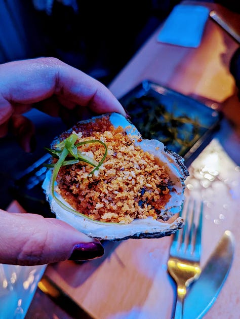 Left to right: Brown butter roasted oysters (golden brown tempura flakes on top of oyster shells); fluke tartare (red fish cut as a tartare, surrounded by a green and white sauce, with macron almonds on top); Gochujang butter roasted oyster (panko flakes topped on top of an oyster shell)