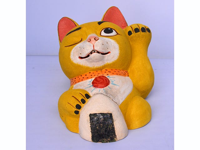 Artwork by Maile Yawata. A cat with a musubi.