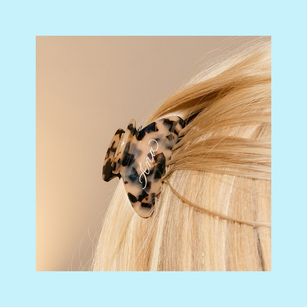 A photo of a claw clip with the name Ana painted on it