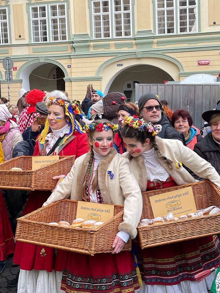 Freshly fried koblihy (Czech carnival doughnuts) being handed out to festival-goers during Masopust.
