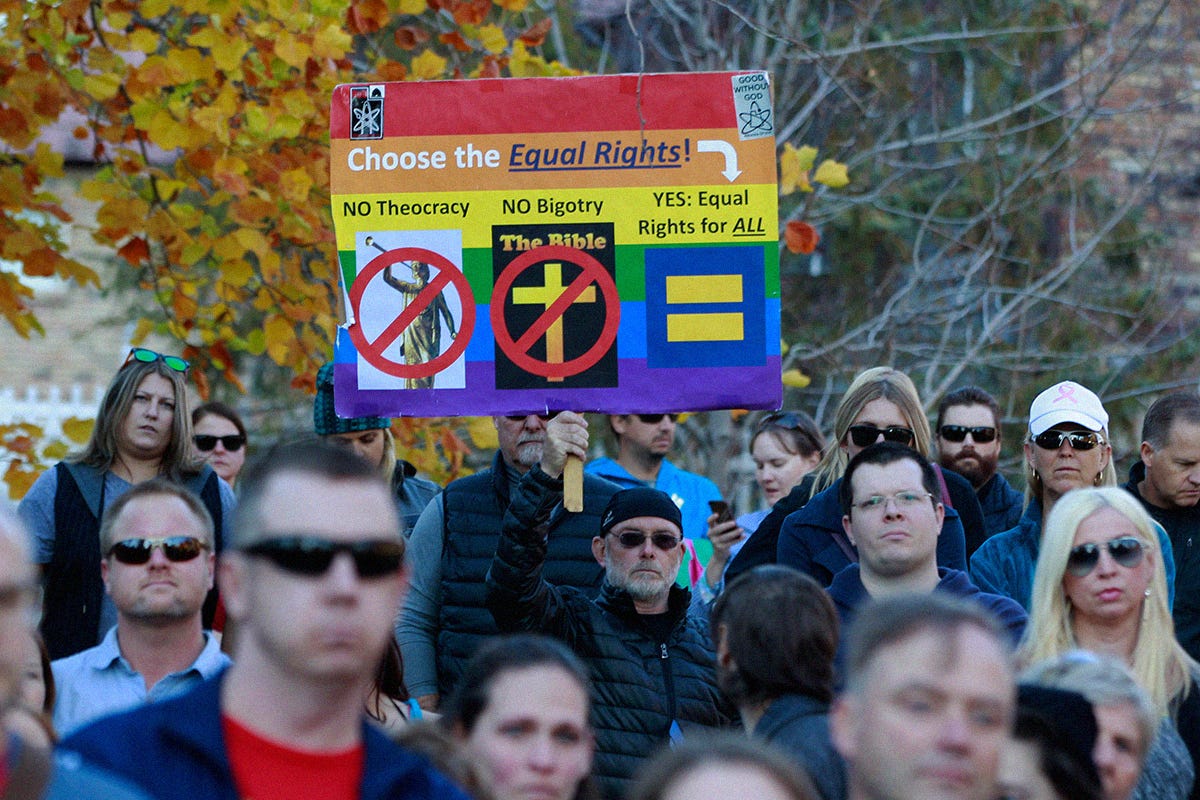 A man holds a protest sign in City Creek Park after many submitted their resignations from the Church of Jesus Christ of Latter-Day Saints in response to a recent change in church policy towards married LGBT same sex couples and their children on November 14, 2015 in Salt Lake City, Utah.