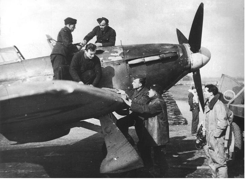 A group of airmen on and around an Hawker Hurricane plane, among them Josef Bryks, on the left, wearing his hat and uniform.