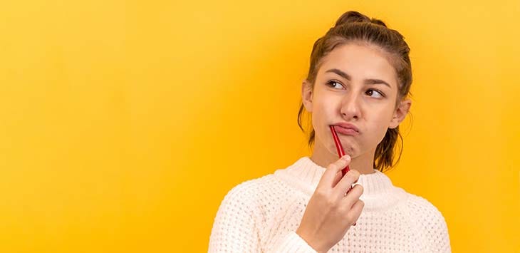 Photo of young woman brushing her teeth.