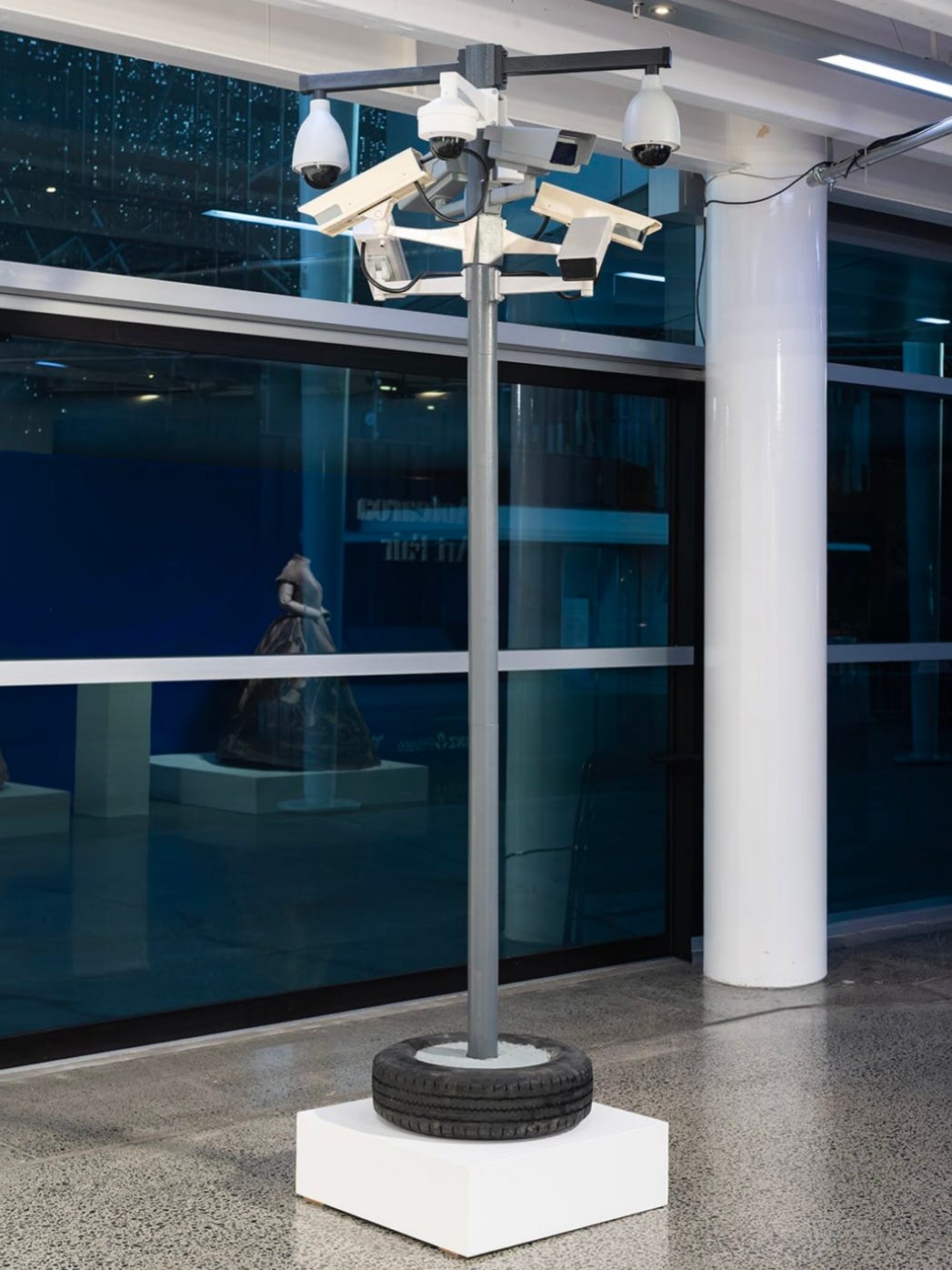 A fuck ton of surveillance cameras on a pole stuck in a tire.
