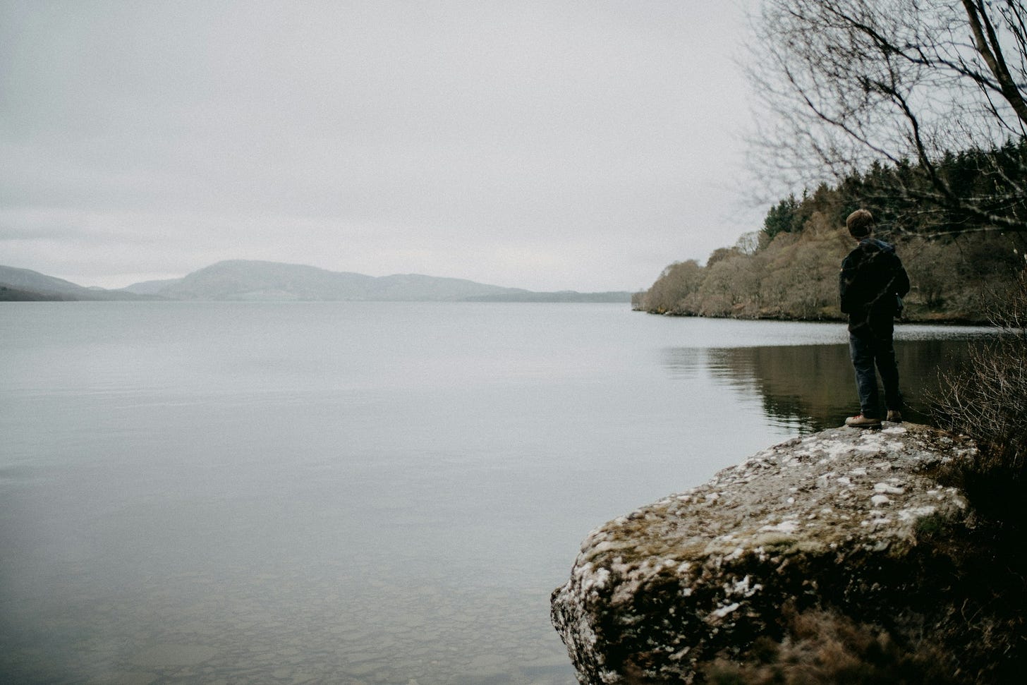 a man overlooking a gloomy lake in Scotland