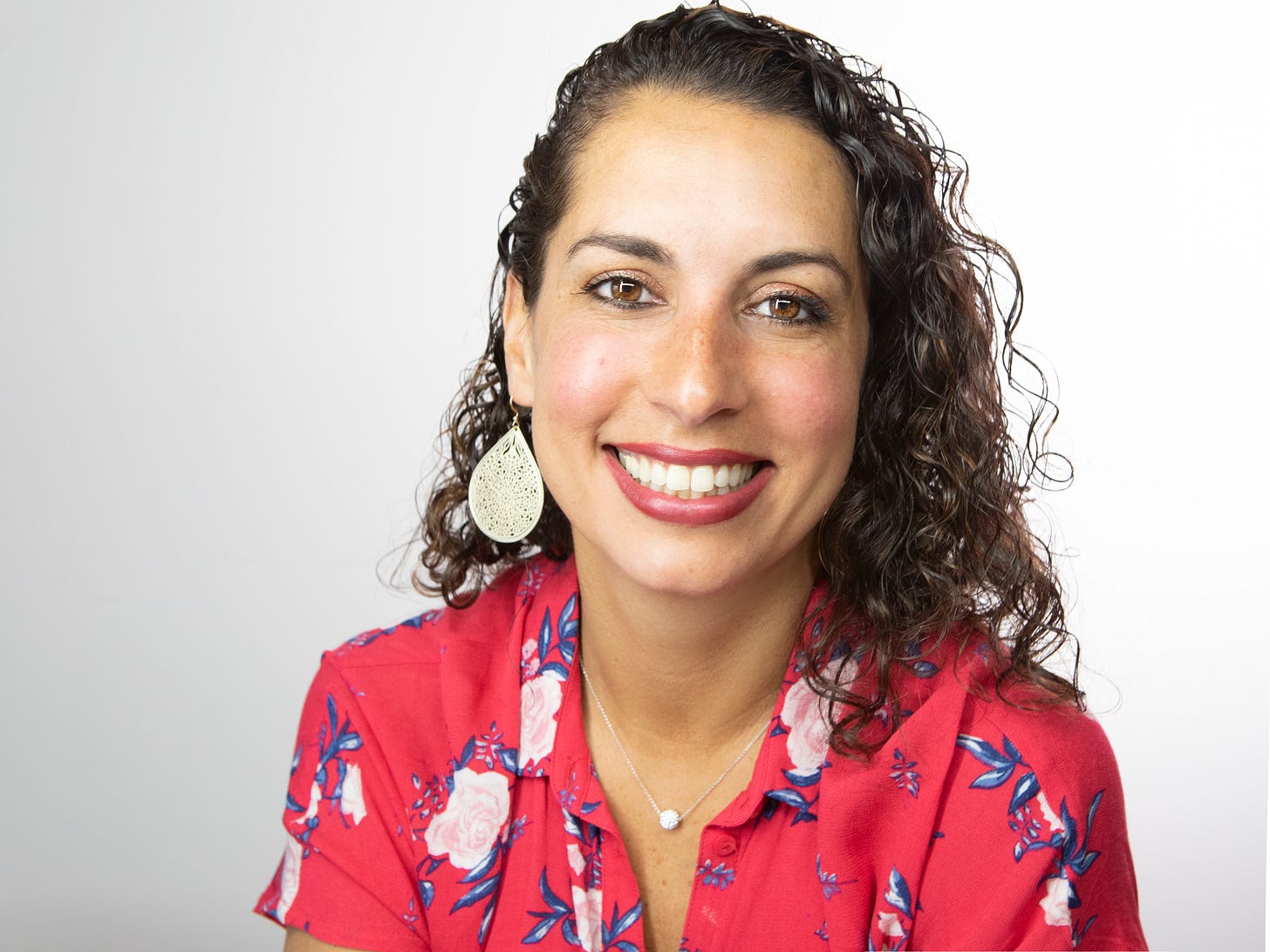 Picture of Andrea Urioste, Co-Founder of Wonder Integrated Group. She's wearing a pink top with a floral pattern. 