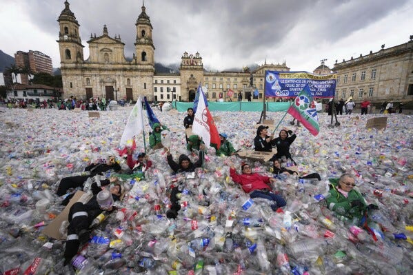 Recyclers lie on plastic bottles blanketing Plaza Bolivar in Bogota, Colombia, as part of a protest against what recyclers consider to be too low a price paid to them by companies that buy recycled materials, Tuesday, June 24, 2025. (AP Photo/Fernando Vergara)