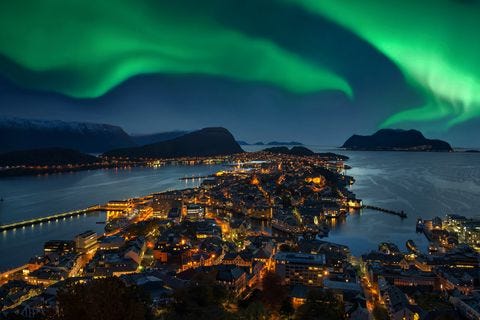 northern lights green aurora borealis over alesund, norway