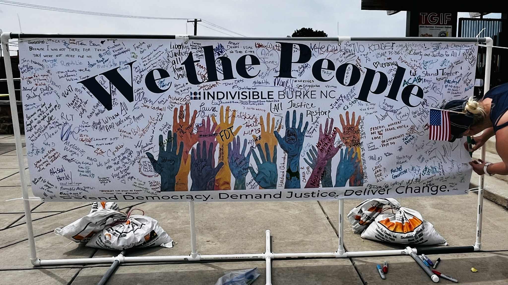 Poster signed by hundreds of demonstrators that reads 'We the People'