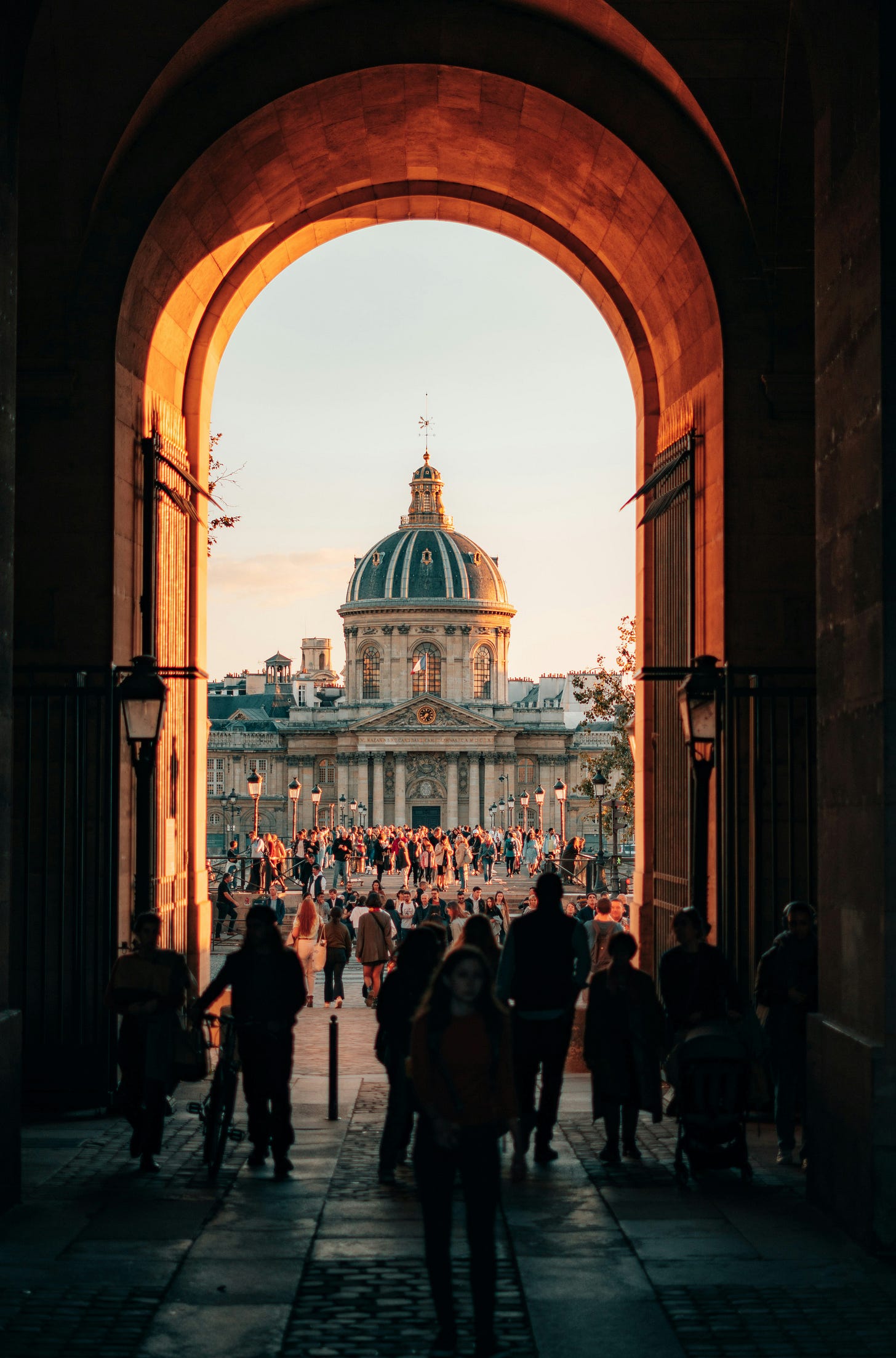 People under a dark archway in Paris.