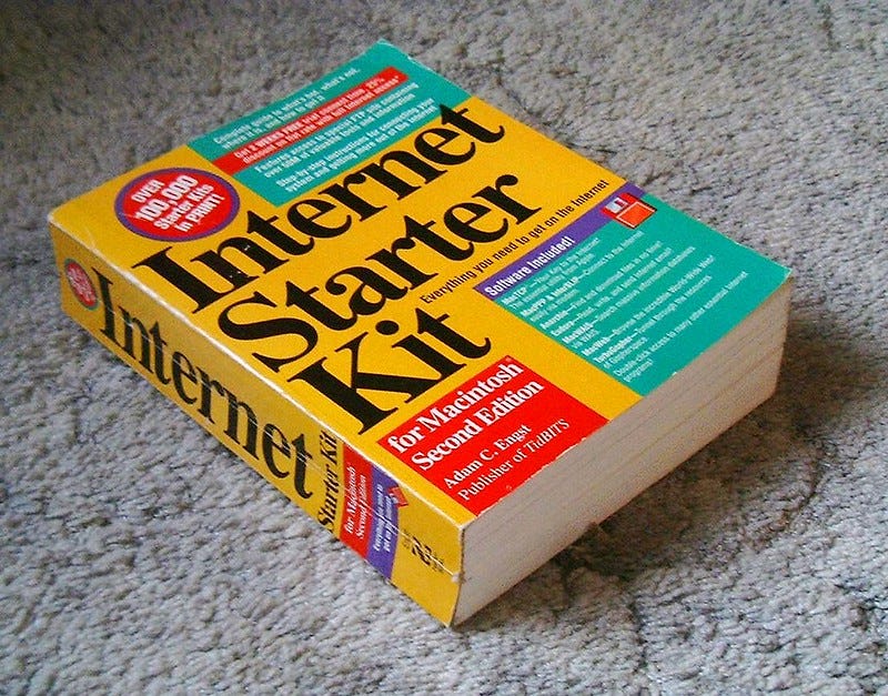 A photo of a large, thick yellow book on a grey carpet. It has 'Internet Starter Kit' on the front and 'for Macintosh Second Edition'.