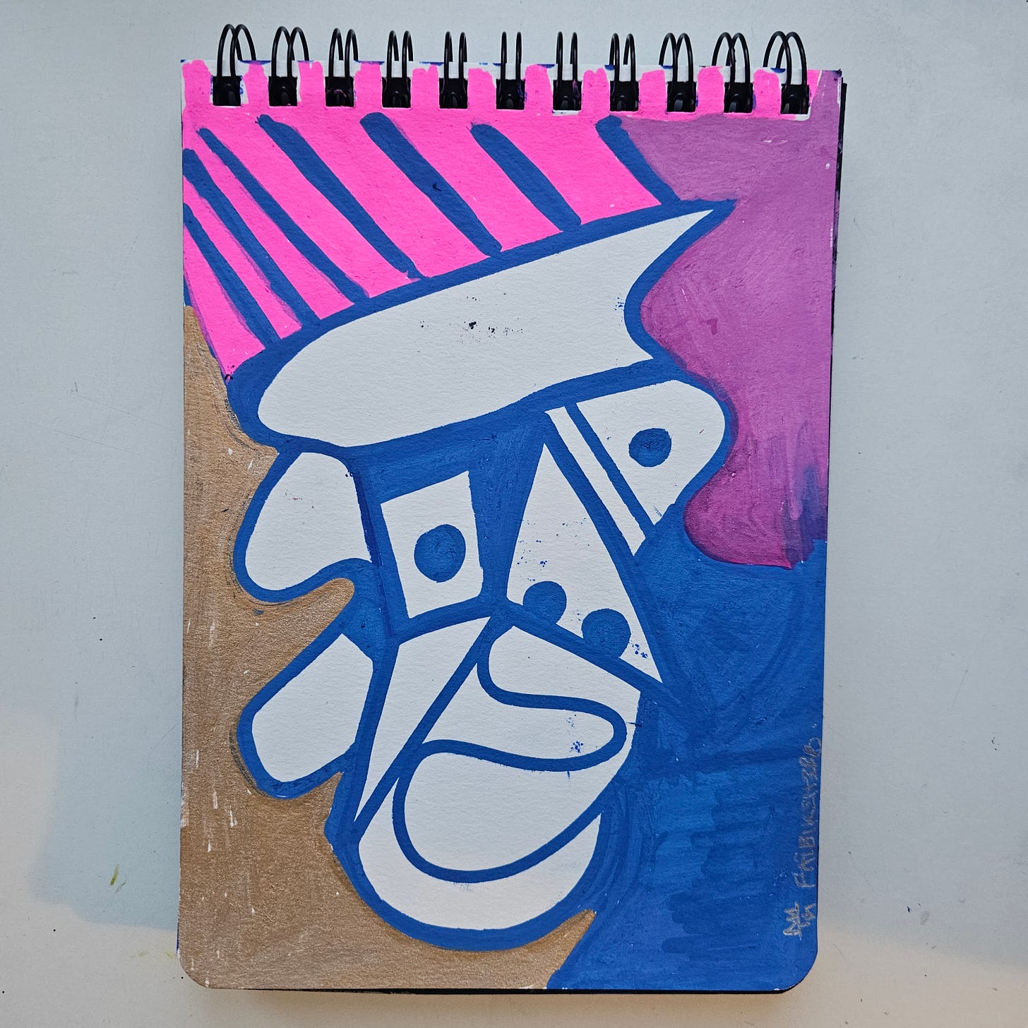 Alt Text: An abstract, Neo-Cubist portrait by artist FatbikeHero features a stylized face composed of geometric shapes in white, blue, and navy. The background contrasts with vibrant stripes of hot pink and a block of purple. The left side reveals the raw tan color of the sketchbook paper.
