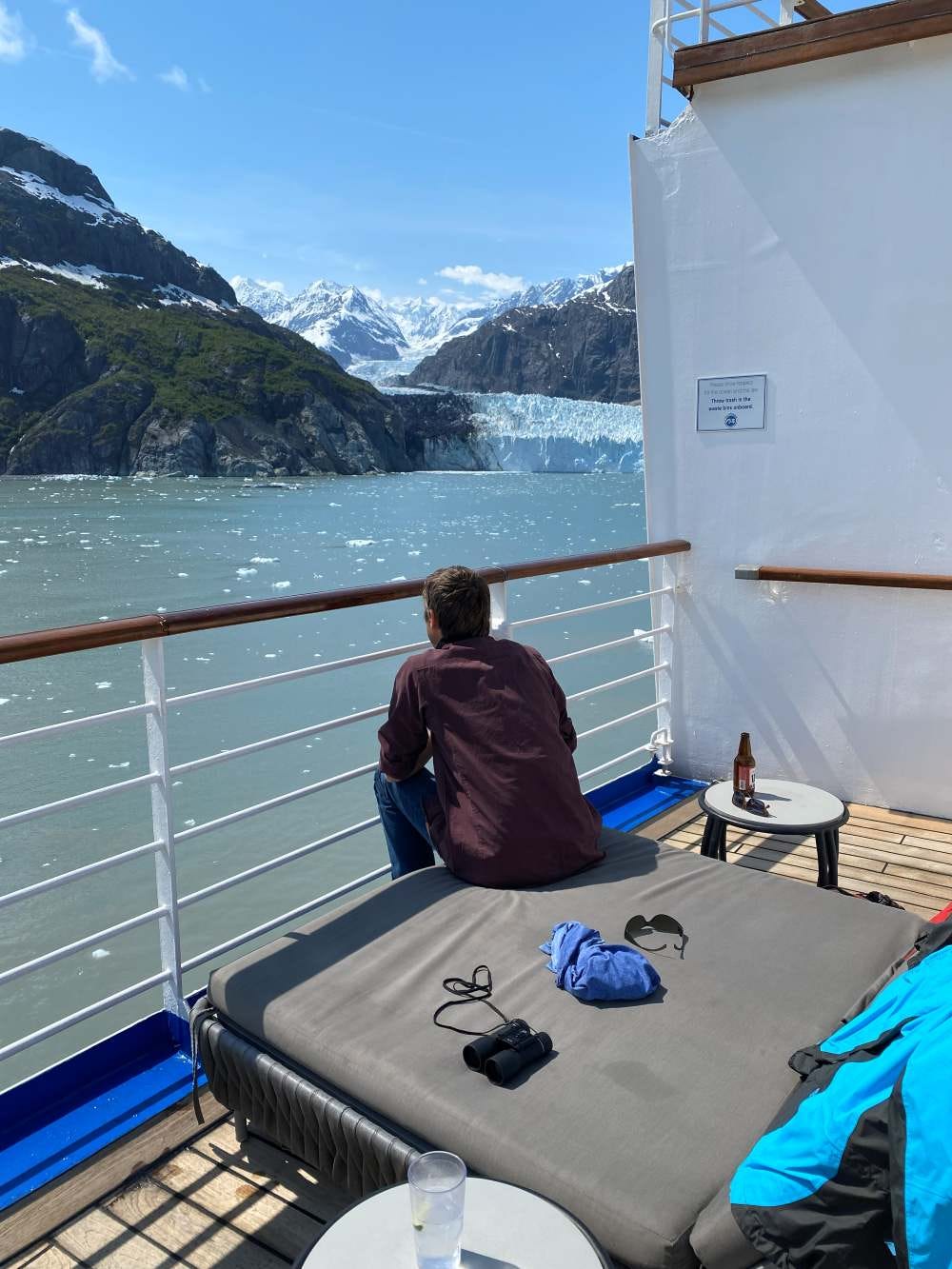 a man watching the water in Glacier bay from a daybed on a cruise ship a man watching the water in Glacier bay from a daybed on a cruise ship