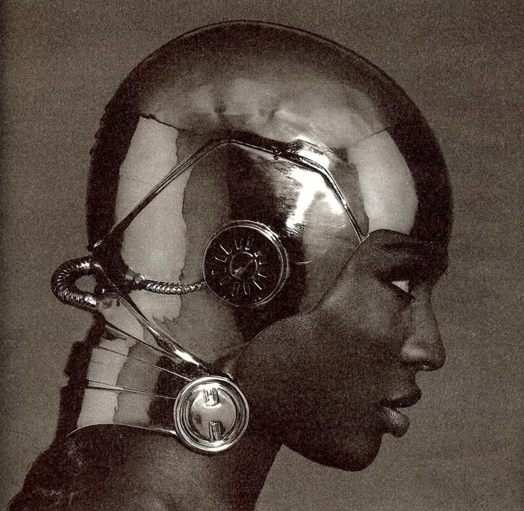 This may contain: a black and white photo of a person wearing a futuristic headpiece