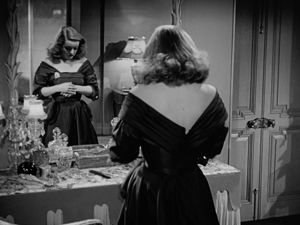 All About Eve | Still features Bette Davis as Margo Channing gazing upon her own reflection. All About Eve | Still features Bette Davis as Margo Channing gazing upon her own reflection.