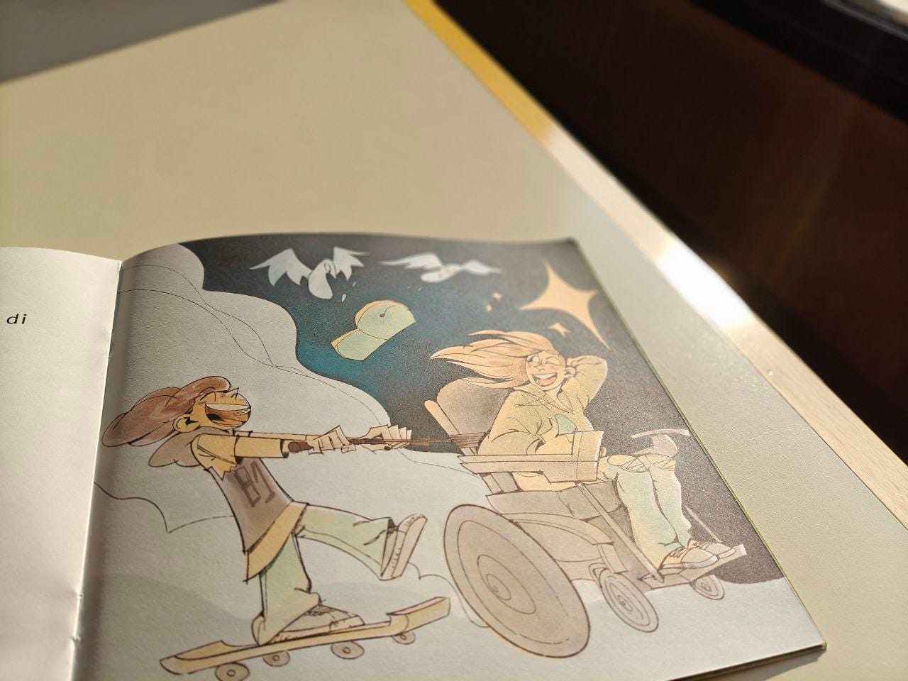 Una pagina della parola GIOCO delle Scatoline effequ con il disegno di una ragazzina sorridente vestita in modo sportivo con felpa con cappuccio e pantaloni larghi mentre sta su uno skateboard e si fa trainare da una ragazza con i capelli lunghi che volano per la velocità, mentre sfreccia sulla sua sedia a rotelle; la ragazza seduta si guarda indietro e fa l'occhiolino all'altra. Nel cielo svolazzano due uccelli azzurri, un guantone da boxe verde e brillano delle stelle gialle. Il cielo è blu scuro. La pagina è appoggiata su un tavolo di legno bianco sporco e nelll'angolino a destra un pezzo di muro. Una pagina della parola GIOCO delle Scatoline effequ con il disegno di una ragazzina sorridente vestita in modo sportivo con felpa con cappuccio e pantaloni larghi mentre sta su uno skateboard e si fa trainare da una ragazza con i capelli lunghi che volano per la velocità, mentre sfreccia sulla sua sedia a rotelle; la ragazza seduta si guarda indietro e fa l'occhiolino all'altra. Nel cielo svolazzano due uccelli azzurri, un guantone da boxe verde e brillano delle stelle gialle. Il cielo è blu scuro. La pagina è appoggiata su un tavolo di legno bianco sporco e nelll'angolino a destra un pezzo di muro.