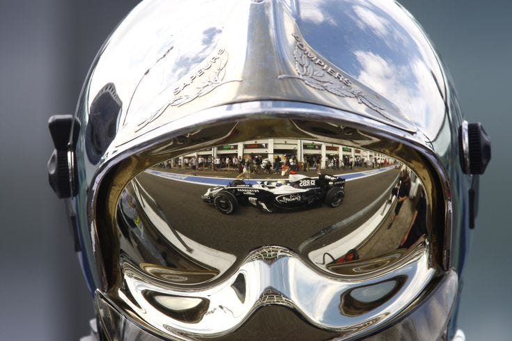 This may contain: the reflection of a race car in a helmet This may contain: the reflection of a race car in a helmet