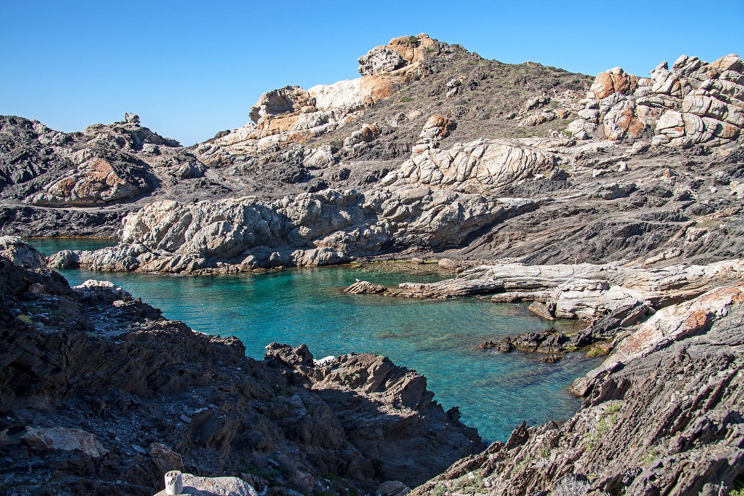 Jagged schist rocks running out into turquoise water at Cap de Creus. Jagged schist rocks running out into turquoise water at Cap de Creus.