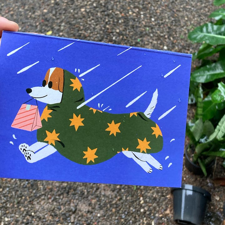 Promotional flyer for the market and a card featuring a dog in a raincoat running through the rain dangling a gift bag from its mouth.