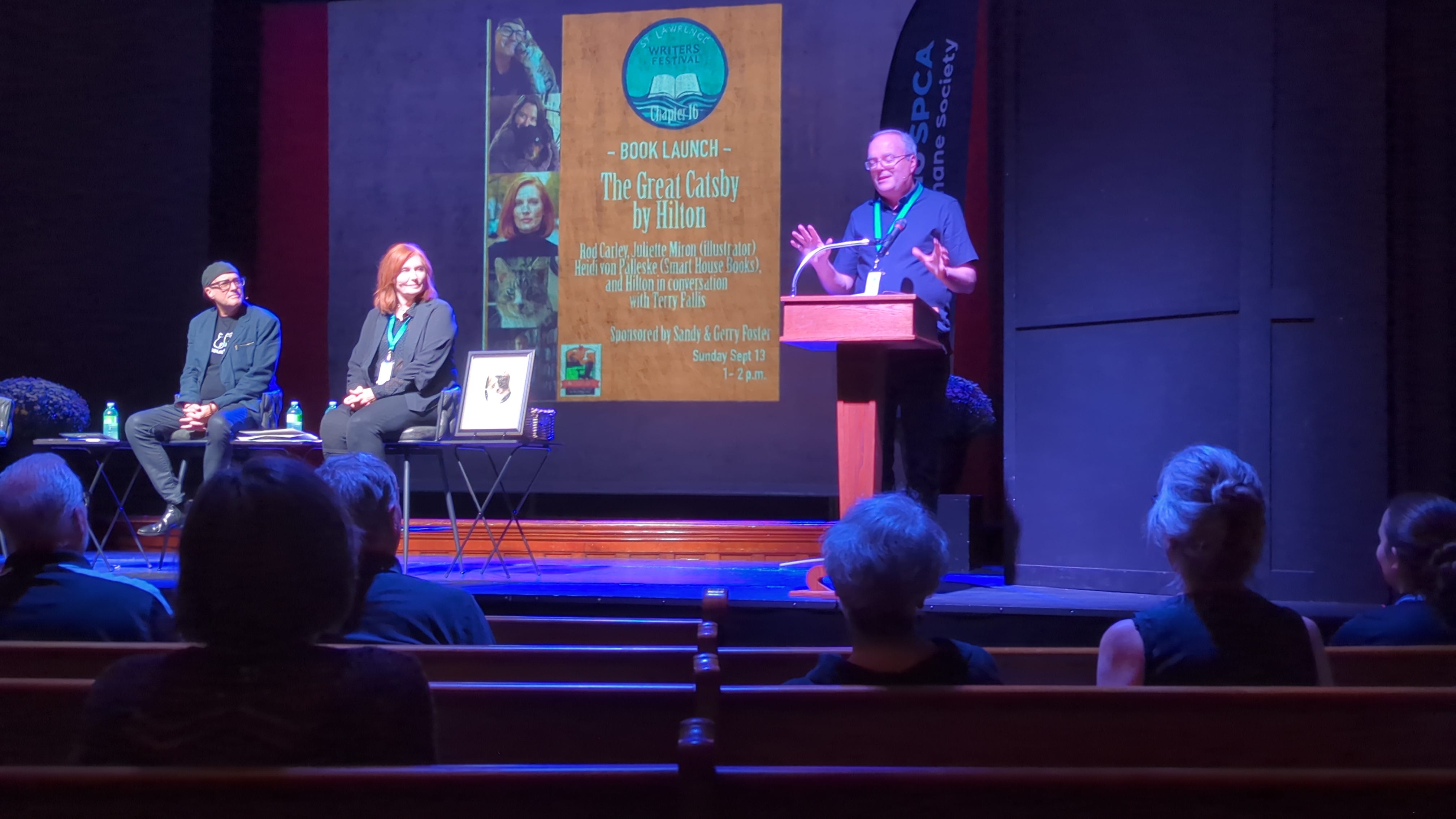 Rod Carley (left), Heidi Von Palleske, Hilton the Cat, and Terry Fallis on stage at the St. Lawrence Writers Festival for the launch of Rod’s (cat’s…) book, The Great Catsby. Rod Carley (left), Heidi Von Palleske, Hilton the Cat, and Terry Fallis on stage at the St. Lawrence Writers Festival for the launch of Rod’s (cat’s…) book, The Great Catsby.