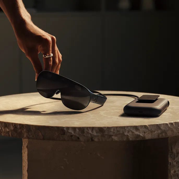 Una persona que está alcanzando unas Meta VR Glasses que están apoyadas en una mesa. Una persona que está alcanzando unas Meta VR Glasses que están apoyadas en una mesa.