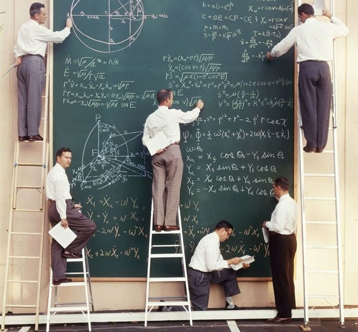 This may contain: several men standing on ladders in front of a blackboard