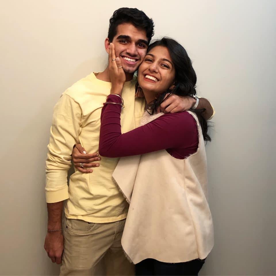 A photo of a brother and sister, both adults, embracing and smiling for the camera. A photo of a brother and sister, both adults, embracing and smiling for the camera.