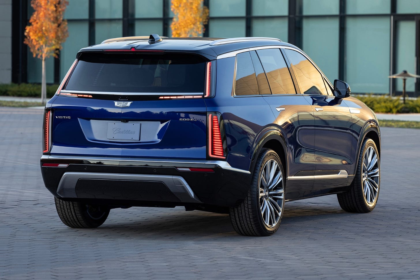 Rear quarter view of a dark blue 2026 Cadillac Vistiq parked in a courtyard.